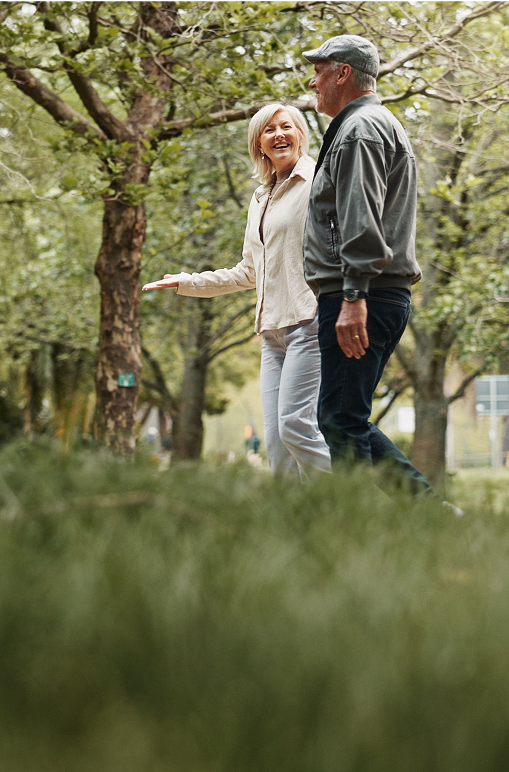 An elderly couple walking together in the woods
